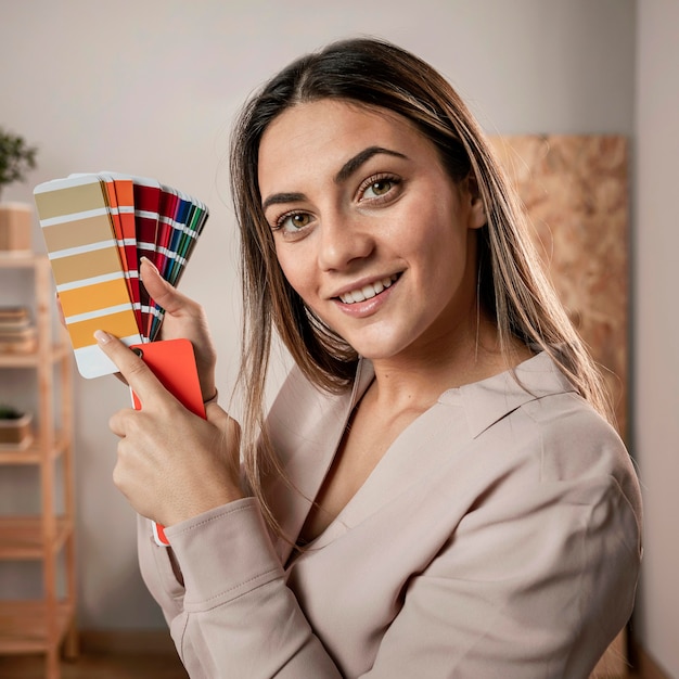 Mujer de tiro medio posando con paleta de colores