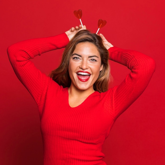 Mujer de tiro medio posando con piruletas