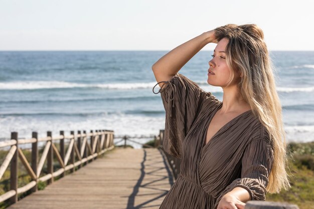 Mujer de tiro medio posando en la playa