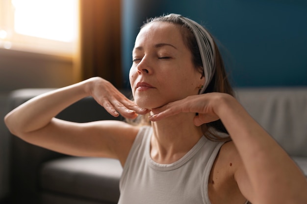 Foto gratuita mujer de tiro medio practicando yoga facial