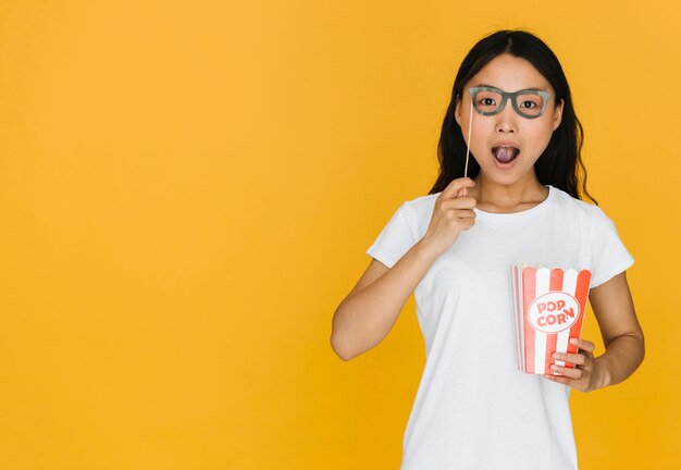 Mujer de tiro medio probándose gafas falsas