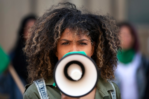 Foto gratuita mujer de tiro medio protestando al aire libre