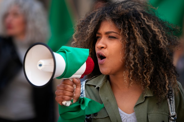 Mujer de tiro medio protestando al aire libre