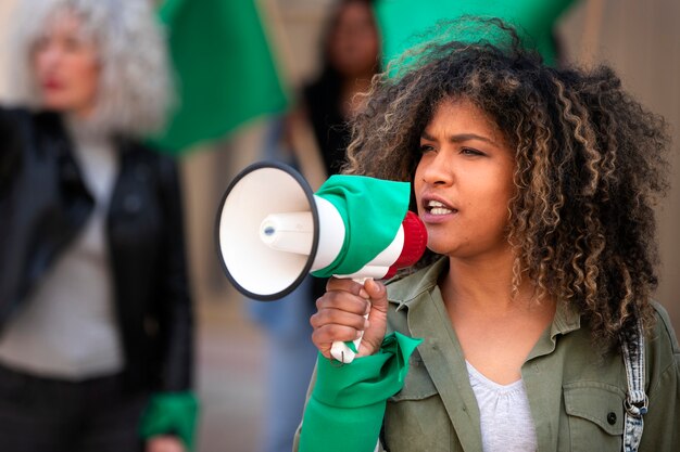 Mujer de tiro medio protestando al aire libre