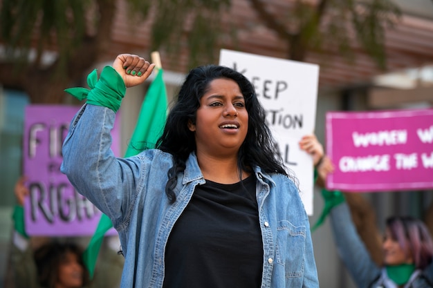 Foto gratuita mujer de tiro medio protestando al aire libre