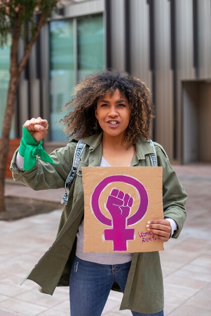 Mujer de tiro medio protestando al aire libre