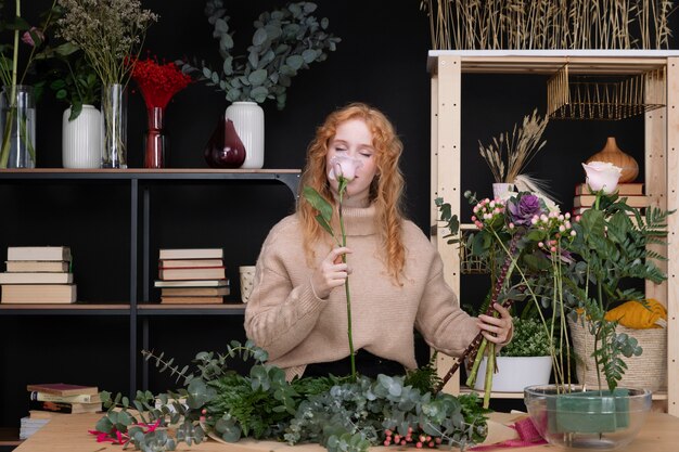 Mujer de tiro medio que huele a flor