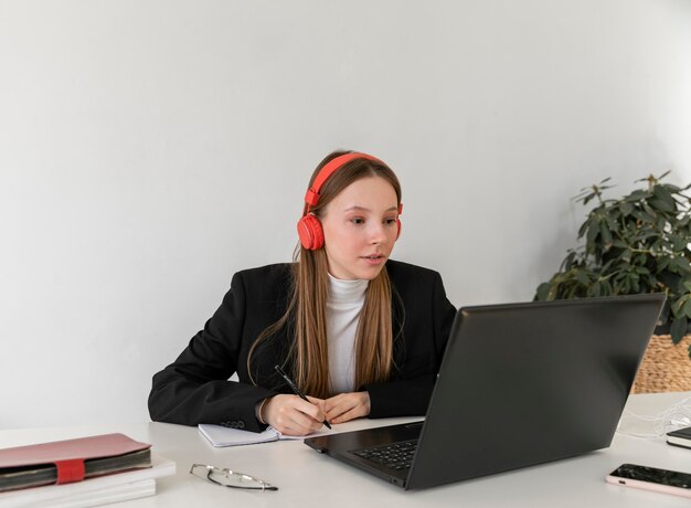 Mujer de tiro medio que trabaja con auriculares