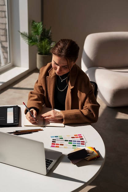 Mujer de tiro medio que trabaja en un proyecto de diseño de interiores.