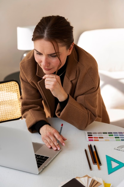 Mujer de tiro medio que trabaja en un proyecto de diseño de interiores.