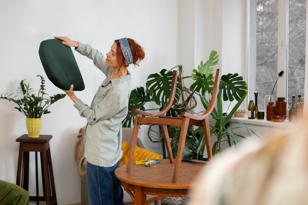 Mujer de tiro medio restaurando muebles.