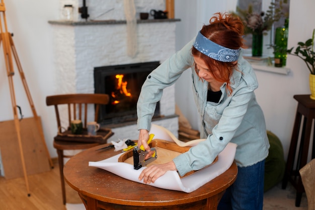 Mujer de tiro medio restaurando muebles.