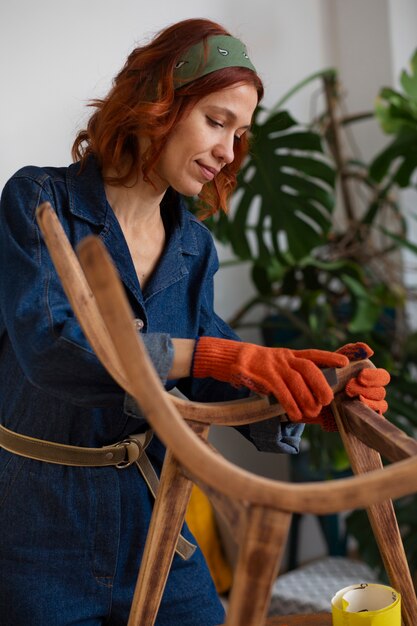 Mujer de tiro medio restaurando muebles.