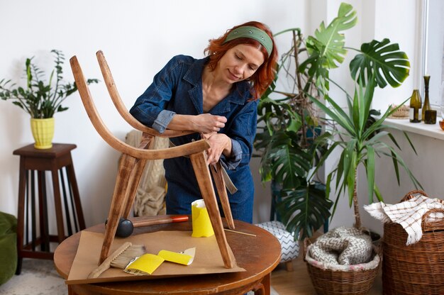 Mujer de tiro medio restaurando muebles.