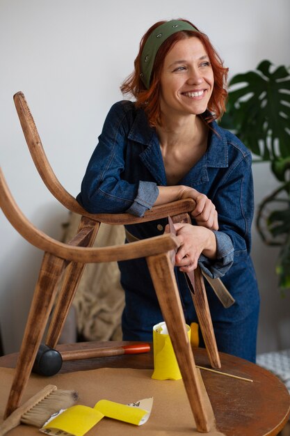 Mujer de tiro medio restaurando muebles.