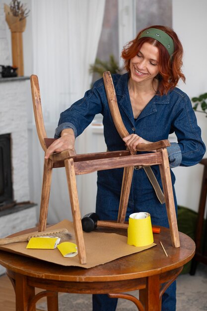 Mujer de tiro medio restaurando muebles.