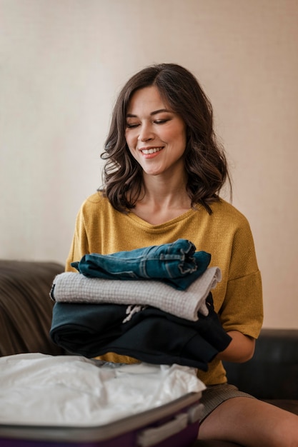 Mujer de tiro medio con ropa doblada