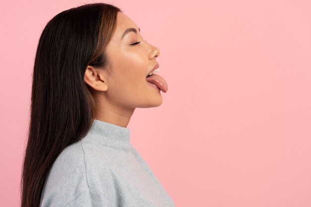 Mujer de tiro medio sacando la lengua