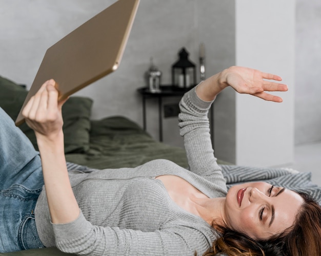 Mujer de tiro medio saludando a la tableta