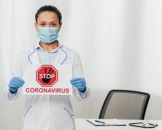 Foto gratuita mujer de tiro medio con signo de coronavirus