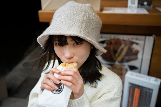 Mujer de tiro medio con sombrero comiendo