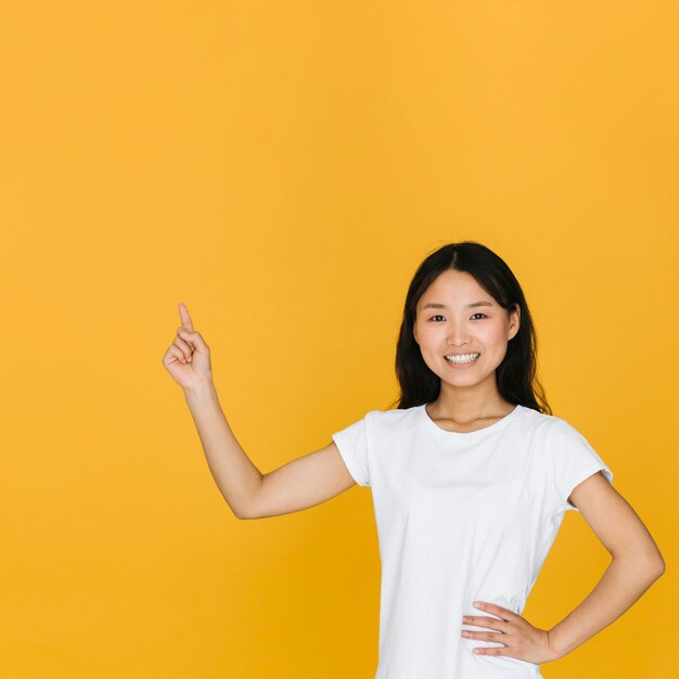 Foto gratuita mujer de tiro medio sonriente apuntando hacia arriba