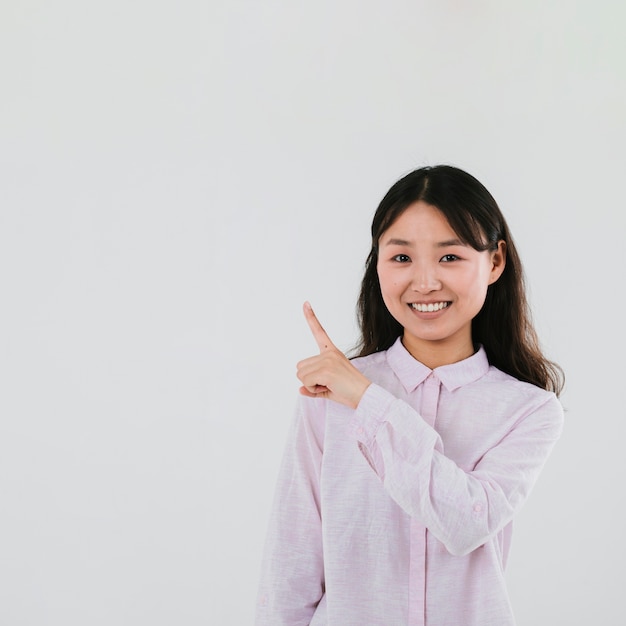 Foto gratuita mujer de tiro medio sonriente apuntando hacia arriba