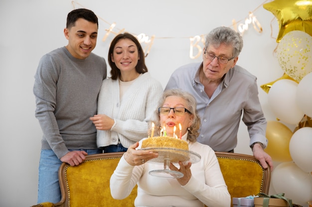 Mujer de tiro medio soplando velas