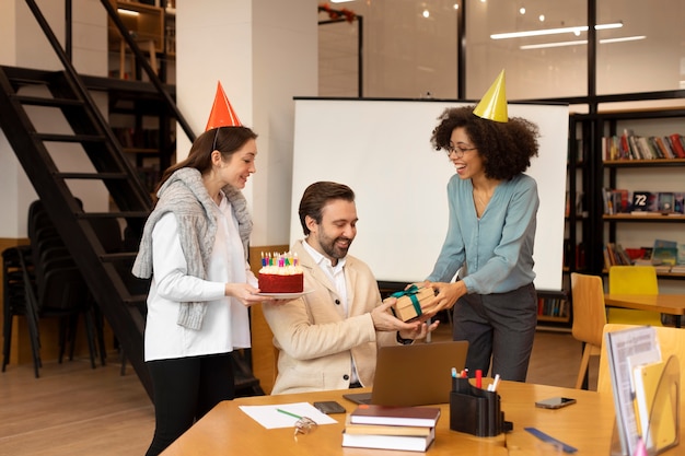 Mujer de tiro medio sorprendiendo a un compañero de trabajo.