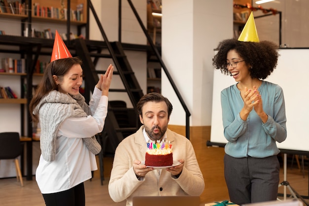 Foto gratuita mujer de tiro medio sorprendiendo a hombre con pastel.