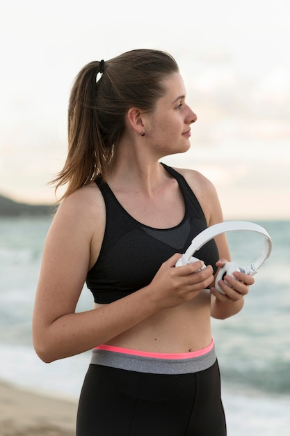 Foto gratuita mujer de tiro medio sosteniendo auriculares