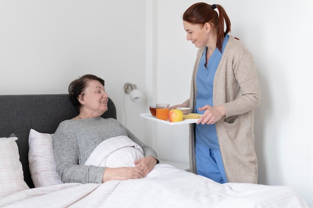 Mujer de tiro medio sosteniendo la bandeja de comida