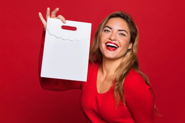 Mujer de tiro medio sosteniendo una bolsa de papel