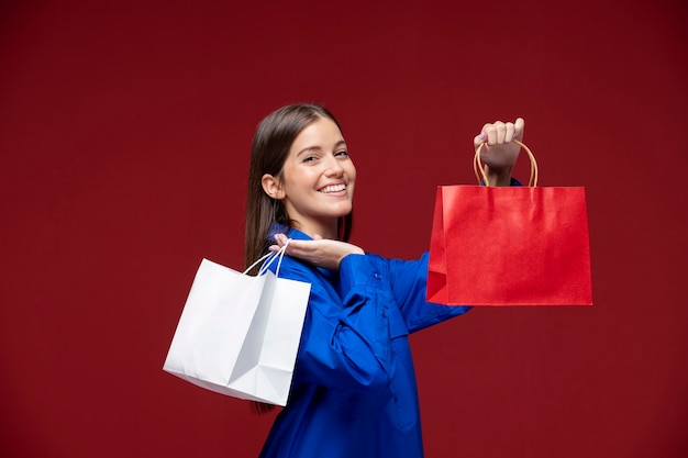 Mujer de tiro medio sosteniendo bolsas de la compra.