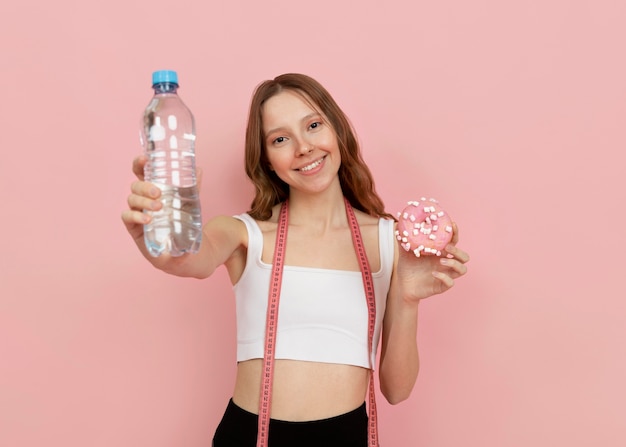 Mujer de tiro medio sosteniendo una botella de agua