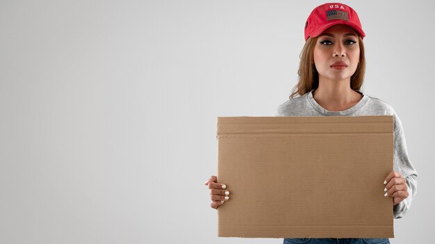 Mujer de tiro medio sosteniendo cartel vacío