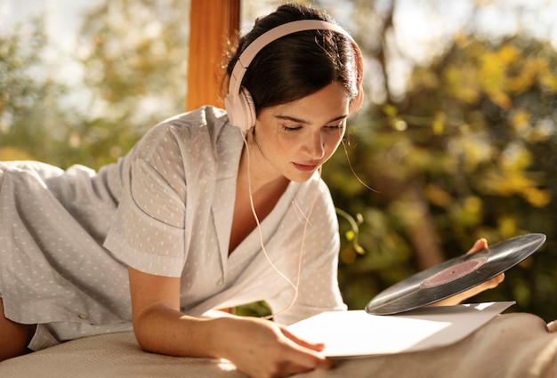 Mujer de tiro medio sosteniendo un disco de vinilo