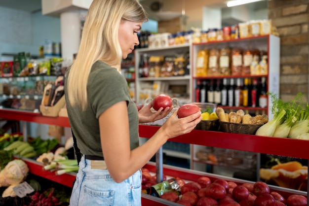 Mujer de tiro medio sosteniendo frutas