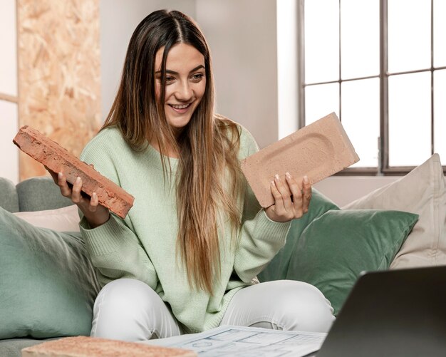 Mujer de tiro medio sosteniendo ladrillos