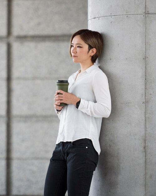 Mujer de tiro medio sosteniendo matraz de café