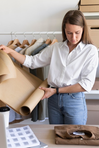 Mujer de tiro medio sosteniendo papel de regalo