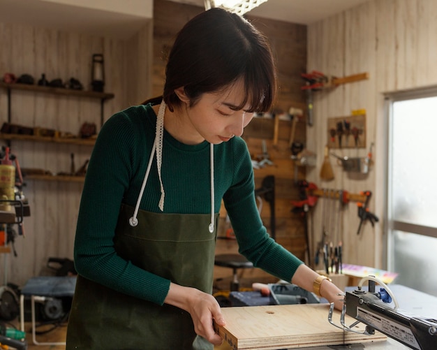 Mujer de tiro medio sosteniendo un pedazo de madera