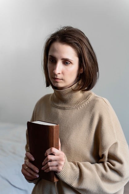 Mujer de tiro medio sosteniendo la sagrada biblia