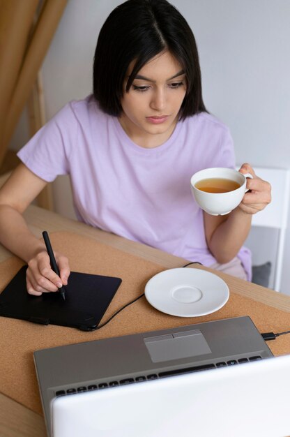 Mujer de tiro medio sosteniendo la taza de café