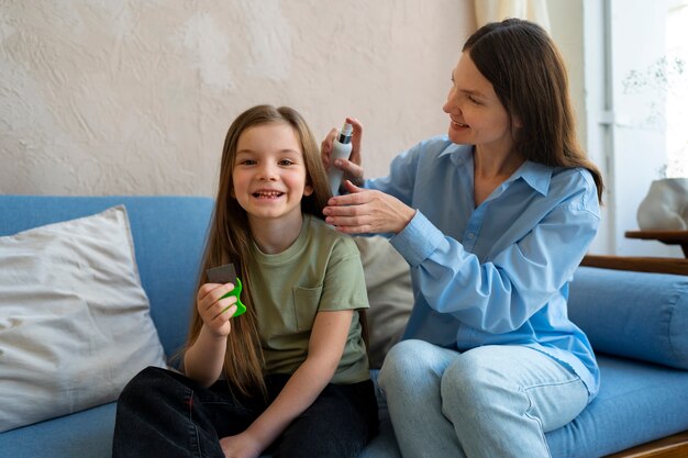 Mujer de tiro medio con spray para el cabello