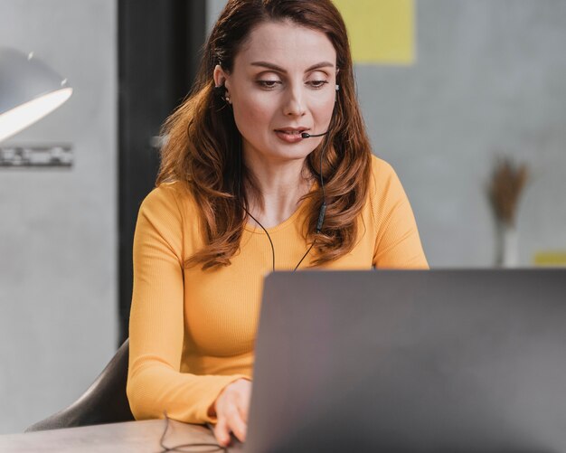 Mujer de tiro medio streaming con portátil