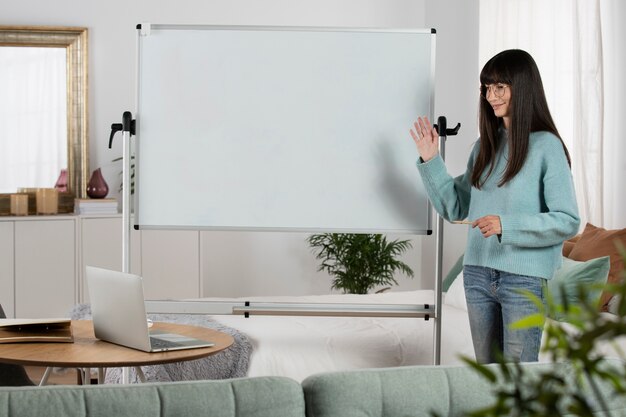 Mujer de tiro medio con tablero blanco.