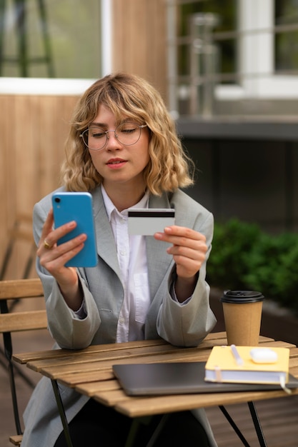 Mujer de tiro medio con tarjeta de crédito