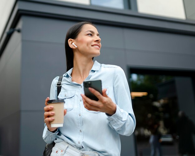 Mujer de tiro medio con teléfono y café