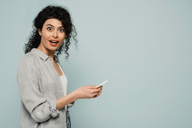 Mujer de tiro medio con teléfono y espacio de copia